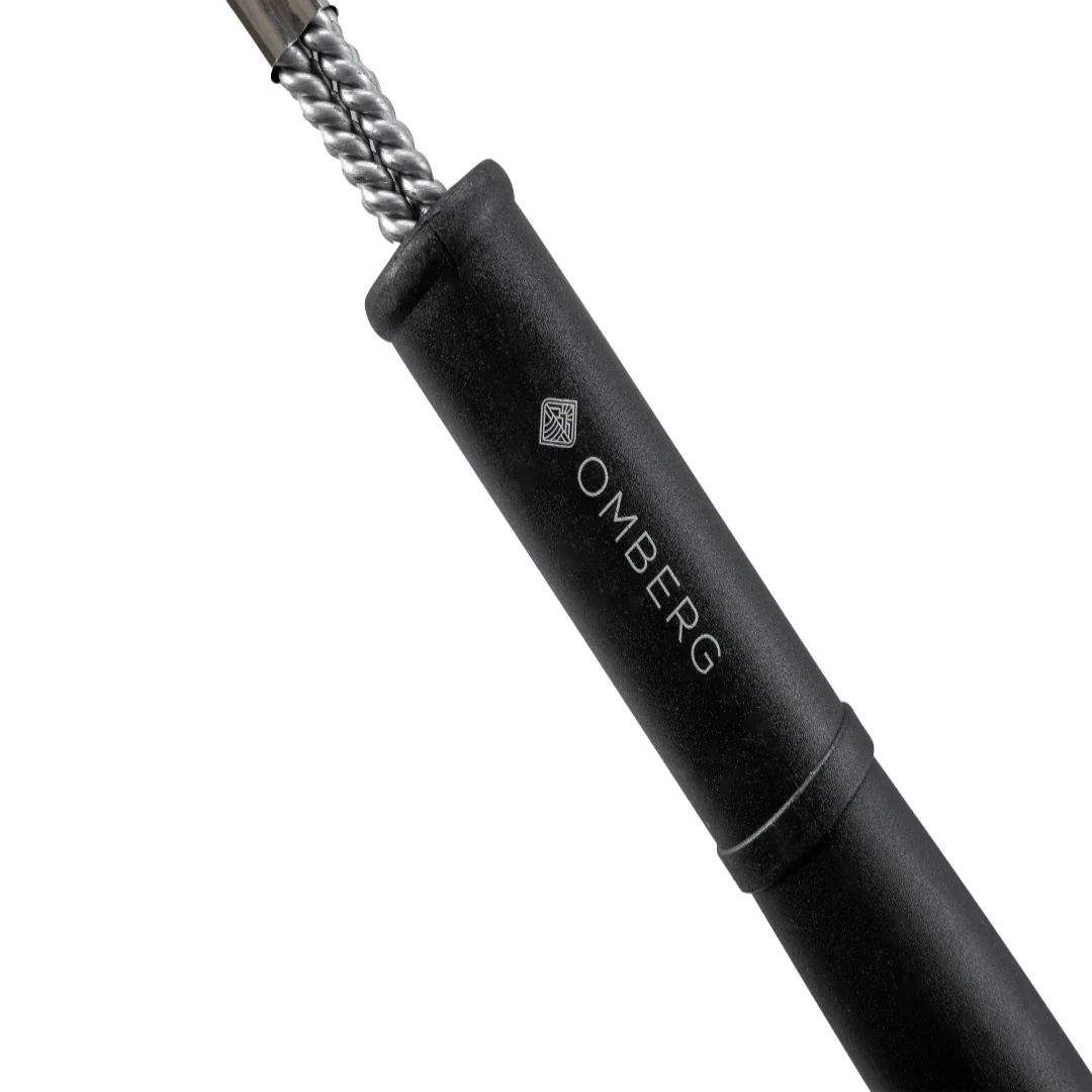 Omberg professional grill brush in use cleaning charcoal grill grates