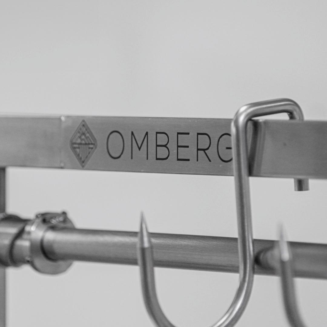 Metal hook with 'OMBERG' branding on a gray background